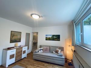 a living room with a couch and a window at Helles, gepflegtes Souterrain Apartment in ruhiger Lage in Düsseldorf