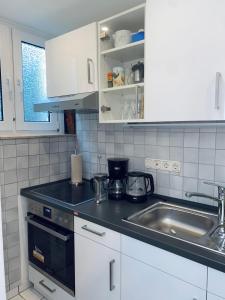 a kitchen with a sink and a counter top at Helles, gepflegtes Souterrain Apartment in ruhiger Lage in Düsseldorf +11 photos