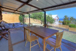 a wooden table and chairs on a patio at Ti Caz Coco - Maison avec Vue mer de 83 m2 - Saint-Leu in Saint-Leu +14 photos