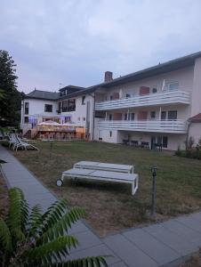 a large apartment building with a bench in the yard at Hotel & Restaurant Rösselsquelle in Ludwigswinkel