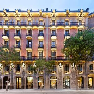 バルセロナにあるモニュメント ホテルの大きなレンガ造りの建物で、窓とバルコニーが付いています。