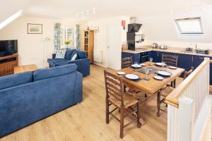 un soggiorno con un tavolo e un divano blu di Relaxing Countryside Retreat with Garden & Parking 