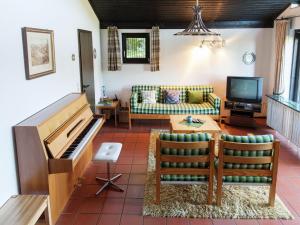 a living room with a piano and a couch at Lissendorf Forest View Lodge in Lissendorf +24 photos