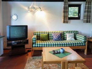 Una sala de estar con un sofá y un televisor. en Lissendorf Forest View Lodge, en Lissendorf