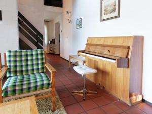a chair and a piano in a room at Lissendorf Forest View Lodge in Lissendorf