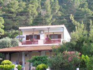 een wit huis met een balkon op een berg bij Villa Dallas in Vourvourou