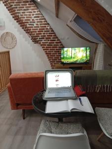 a laptop computer sitting on a table in a living room at Cozy Loft in Hazebrouck