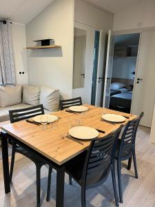 a dining room table with chairs and a couch at Camping Le Roc in Vairé