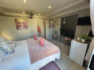 a bedroom with a bed with pink stuffed animals on it at Stellies Accommodation - Room 2 in Keetmanshoop