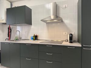 a kitchen with black cabinets and a stove top oven at Girasole Guest House in Verona