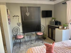 ein Schlafzimmer mit Stühlen, einem Tisch und einem Fenster in der Unterkunft Stellies Accommodation - Room 2 in Keetmanshoop