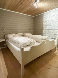 a bedroom with a bed with white sheets and pillows at Mountain Cabin With Ski Tracks Nearby in Øyer