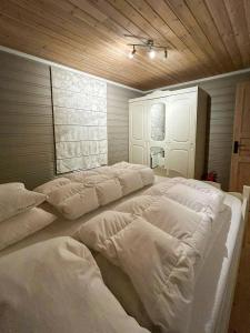 a room with four large white beds in it at Mountain Cabin With Ski Tracks Nearby in Øyer