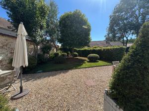 an umbrella sitting in the middle of a garden at Le studio du Clos du Bourgage in Saint-Pierre-dʼAutils