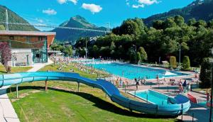 a large swimming pool with a slide in a park at La Chaumine - Beautiful & Stylish 2 Floor Apartment With Terrace in Montriond