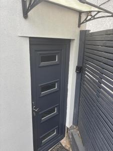 a blue door on a house with a gate at Umazis Bespoke Properties- The Hyde in The Hyde