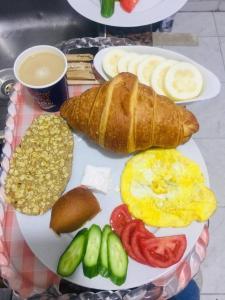 a plate of breakfast food with eggs bread and vegetables at Crown Hotel royal in Cairo
