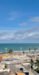 a parking lot next to a beach with the ocean at Apartamento na praia em Natal in Natal