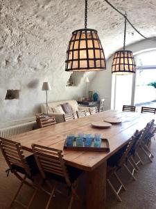 una sala da pranzo con un tavolo di legno e due lampade a sospensione di la bergerie de Haute Provence a Bevons