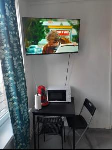 mesa con ordenador portátil y TV en la pared en T2 rénové proche métro, en Lille