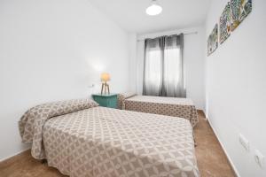 a small room with two beds and a window at Apartamentos Madrid in Torrevieja