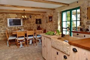 a kitchen and dining room with a table and a television at Holiday home Olea in Malinska