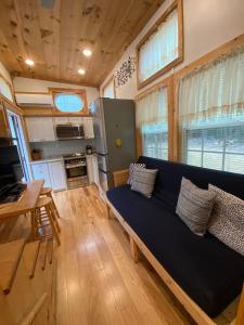 Una sala de estar con un sofá azul y una mesa. en True Tiny Home & Community - 6 Mins To Downtown, en Mentone