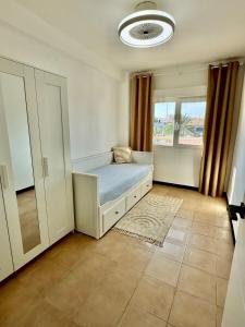 Schlafzimmer mit einem Bett, einem Fenster und einem Spiegel in der Unterkunft The Cozy Coast in Piles