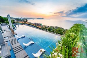 a swimming pool with a view of the water at Apec Mandala Mui Ne by LHG - Sea View, Infinity Pool, Alacarte, 17m to Bàu Trắng Bình Thuận in Mui Ne