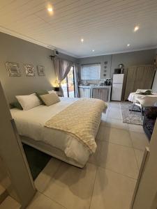 a bedroom with a large bed and a kitchen at Stellies Accommodation - Room 3 in Keetmanshoop