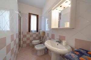 a bathroom with a sink and a toilet and a mirror at La Conchiglia in Seccheto +5 photos
