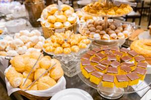 a display of pastries and other desserts on a table at Hotel JP Ribeirão Preto Resort & Convenções by Nacional Inn in Ribeirão Preto