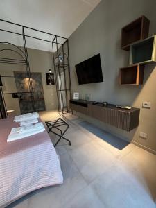 a room with a bed and a flat screen tv at Donna Sofia in Torre Annunziata