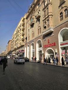 a group of people walking down a street in front of buildings at Hotel velvet One in Cairo