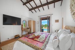 FontvieilleVilla Horizon - 5min from Monaco - Ideal Groups - Panoramic view - Chimney - Parking - Premium Services - Calm的一间卧室，有一张床，墙上有一台电视