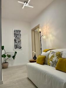 Camera bianca con letto e ventilatore a soffitto. di Studio Park Residence Apartment a Râmnicu Vâlcea