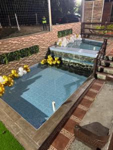 a swimming pool with fruits and vegetables on the ground at Palmerai BUCAY in Cumanda