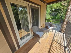un porche cubierto con sillas y mesa en River's Edge, en Gatlinburg