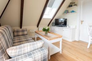 a living room with a couch and a tv at Sylter Wohlfühlnest, App 2 in Wenningstedt
