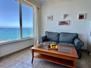 a living room with a couch and a table with fruit on it at Direct at the beach - Arguineguin in Arguineguín