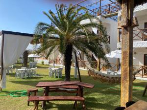 een hangmat en een palmboom naast een gebouw bij Pousada Villa La Creta in Amontada