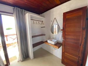 een badkamer met een wastafel en een spiegel aan de muur bij Pousada Villa La Creta in Amontada