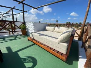 een bed op het terras van een huis bij Pousada Villa La Creta in Amontada