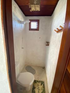 een kleine badkamer met toilet en raam bij Pousada Villa La Creta in Amontada