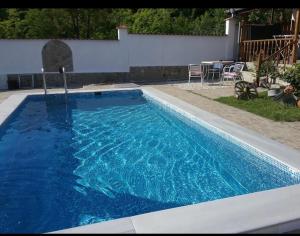 a swimming pool with blue water in a yard at Семеен Хотел Сандим in Kŭrdzhali