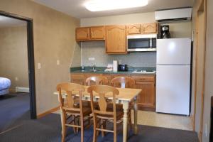 a kitchen with a table and chairs and a refrigerator at Adventure Inn in Ely
