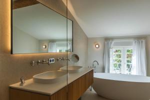 a bathroom with two sinks and a large mirror at La Villa des Vignes in Saint-Émilion