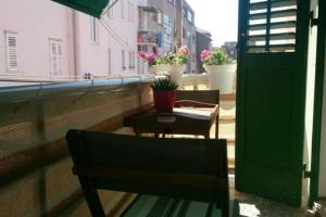 einen Balkon mit 2 Stühlen, einem Tisch und einem Fenster in der Unterkunft Apartment Spalatina in Split