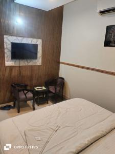 a bedroom with a bed and a tv and a table at HOTEL SATYA in Dehradun