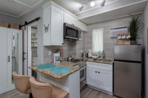 una cucina con armadi bianchi e ripiano in granito di Tropic Terrace Suite #9 - Beachfront Resort a St Pete Beach